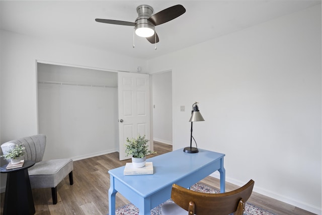 office area with baseboards, wood finished floors, and a ceiling fan