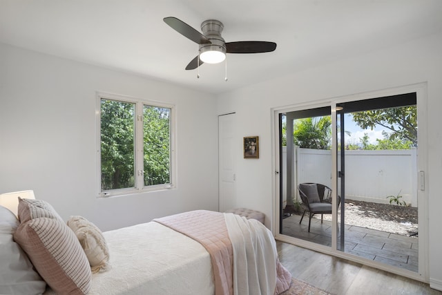 bedroom with ceiling fan, wood finished floors, and access to exterior