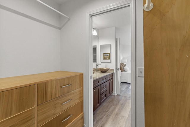 ensuite bathroom featuring ensuite bath, vanity, and wood finished floors