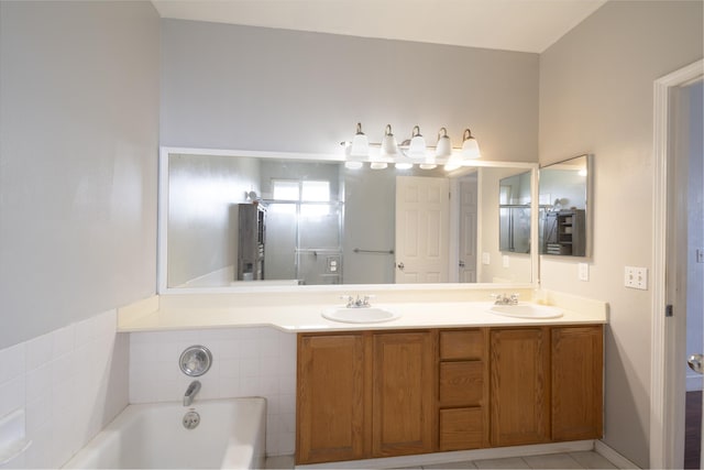 bathroom featuring vanity, tile patterned flooring, and a bathtub