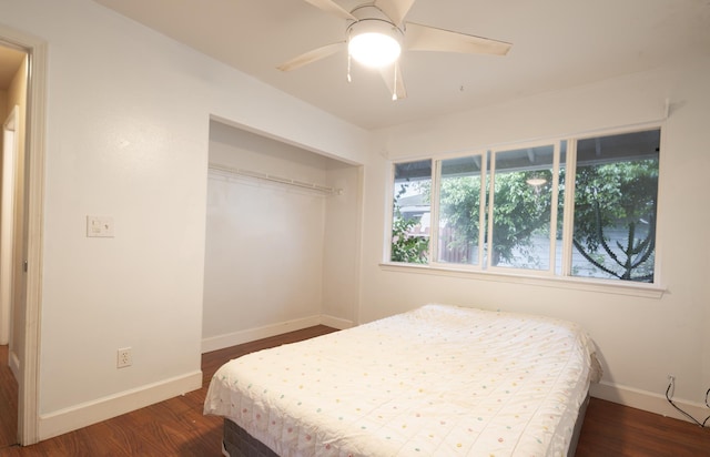 bedroom with dark hardwood / wood-style floors, ceiling fan, and a closet