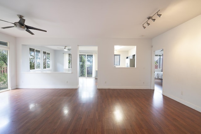 unfurnished living room with ceiling fan and dark hardwood / wood-style flooring