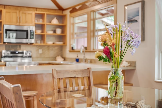 19 Hoku Pl, Paia, HI 96779 - kitchen with stainless steel microwave, open shelves, decorative backsplash, a sink, and light countertops