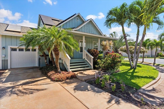 view of front of house featuring solar panels, a garage, covered porch, and a front yard