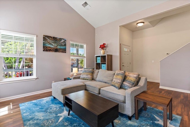 living room featuring high vaulted ceiling and dark wood-type flooring