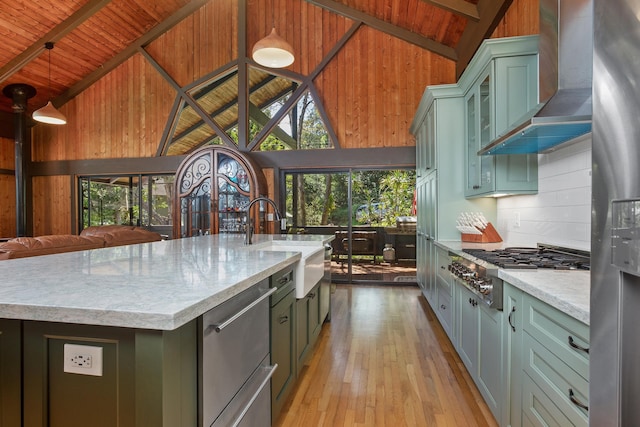 kitchen with wooden ceiling, a kitchen island with sink, sink, wall chimney range hood, and light wood-type flooring