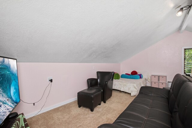 bedroom with vaulted ceiling, light colored carpet, baseboards, and a textured ceiling