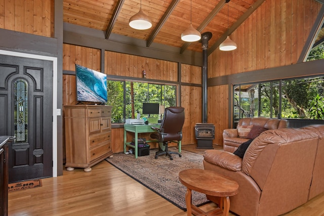 interior space with light wood-type flooring, wood walls, high vaulted ceiling, and a wealth of natural light