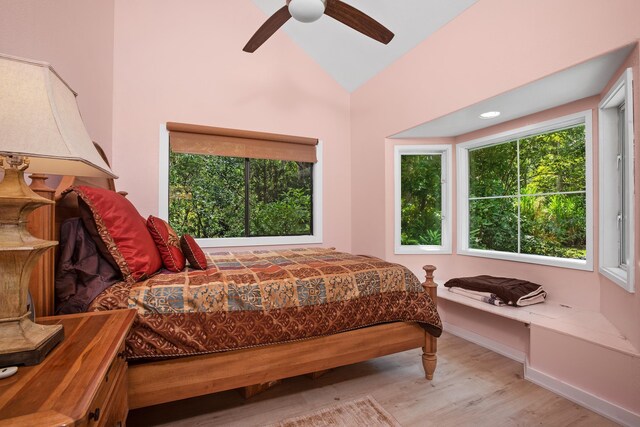bedroom with lofted ceiling, wood finished floors, baseboards, and ceiling fan