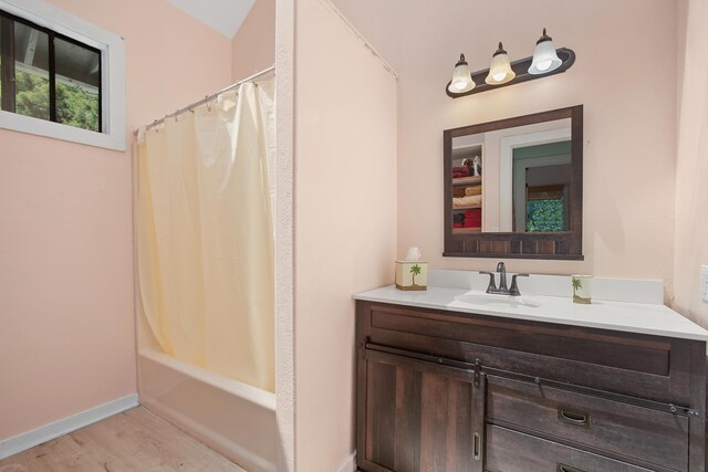 full bath featuring shower / bathtub combination with curtain, baseboards, wood finished floors, and vanity