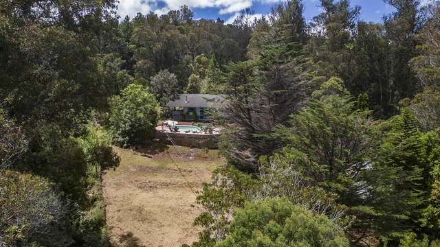drone / aerial view featuring a wooded view