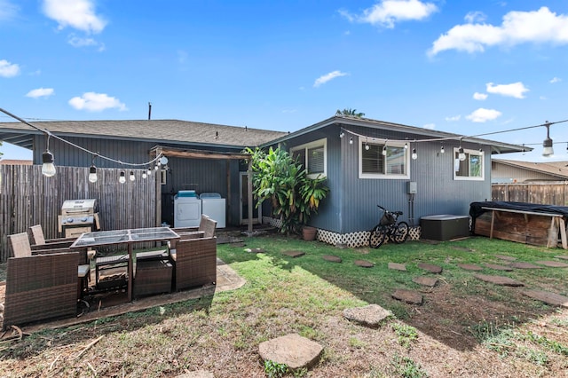 rear view of property featuring washing machine and clothes dryer