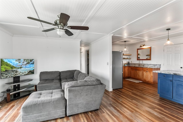 living room with ornamental molding, dark hardwood / wood-style floors, sink, and ceiling fan