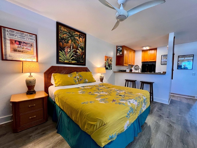 bedroom featuring black fridge, ceiling fan, and dark hardwood / wood-style flooring