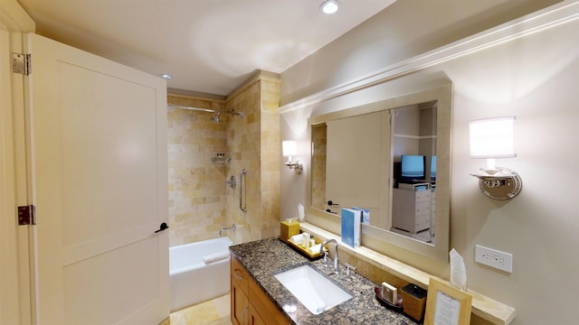 bathroom featuring tiled shower / bath combo and vanity