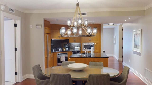 dining room featuring crown molding, a chandelier, sink, and dark hardwood / wood-style flooring