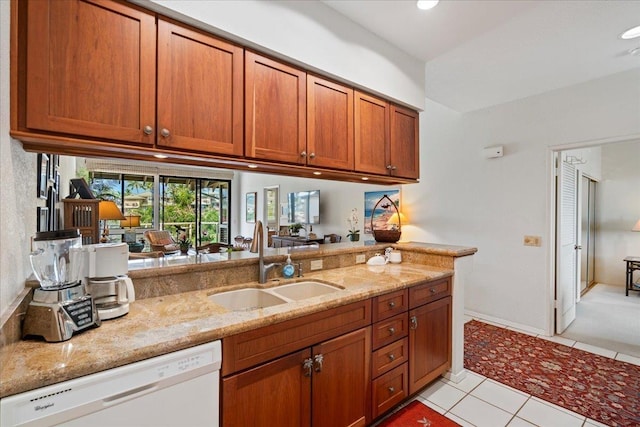 kitchen featuring white dishwasher, sink, light stone counters, and light tile patterned floors