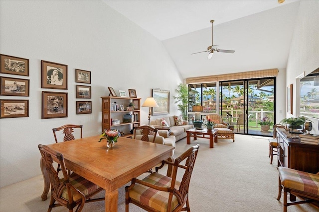 carpeted dining area with high vaulted ceiling and ceiling fan