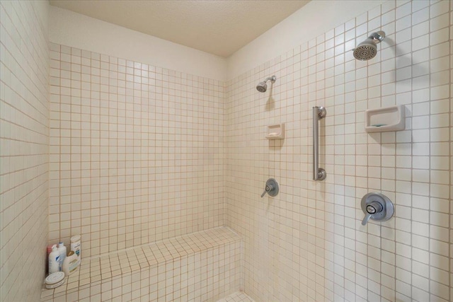 bathroom featuring a tile shower and a textured ceiling