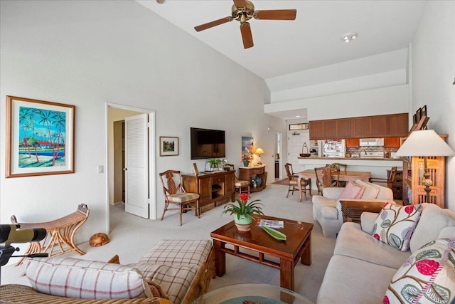 carpeted living room featuring high vaulted ceiling and ceiling fan