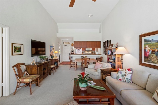 carpeted living room featuring a high ceiling and ceiling fan