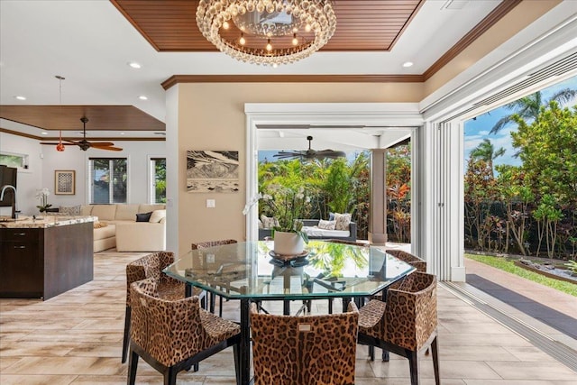 dining space featuring ceiling fan with notable chandelier, wooden ceiling, a tray ceiling, and crown molding