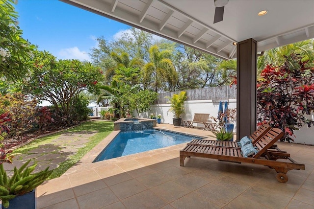 view of swimming pool featuring ceiling fan, a patio, and an in ground hot tub