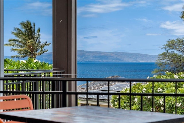 balcony featuring a water and mountain view