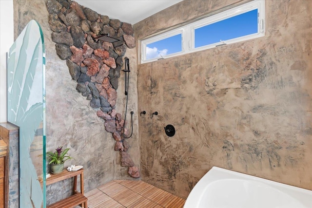 bathroom with a tub to relax in and tile patterned floors