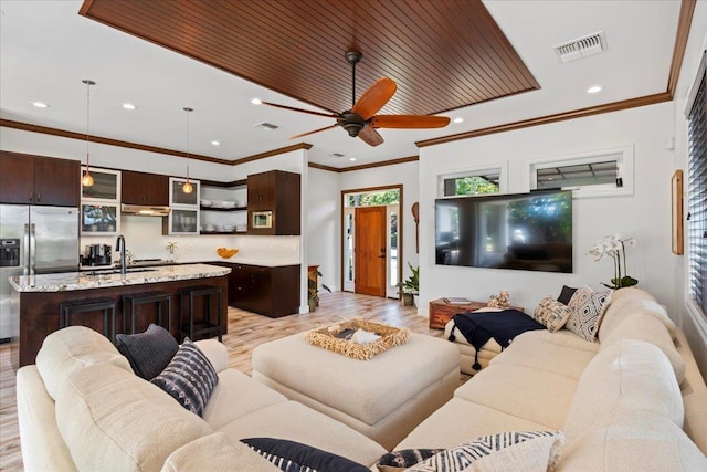 living room featuring ceiling fan, sink, light wood-type flooring, ornamental molding, and wooden ceiling