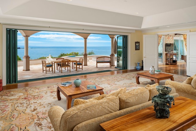 living room with a water view and light hardwood / wood-style flooring