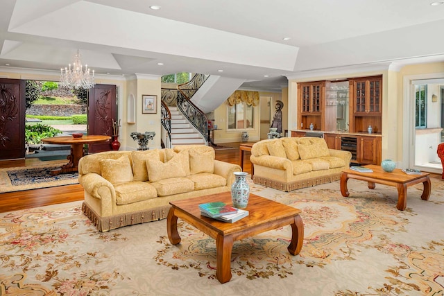 living room with a chandelier, indoor bar, light hardwood / wood-style flooring, and beverage cooler