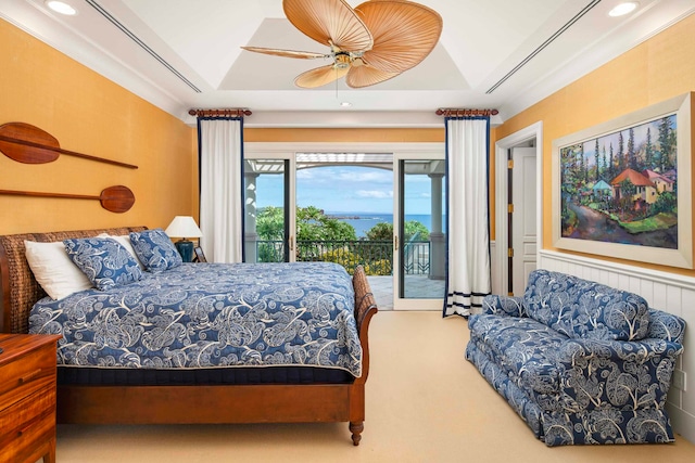 carpeted bedroom featuring a tray ceiling, access to exterior, and ceiling fan