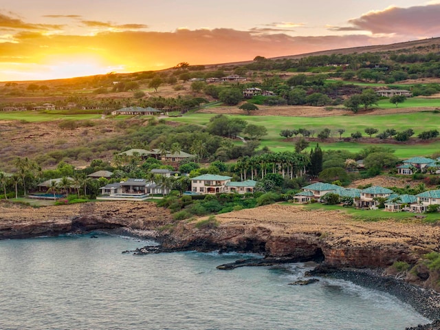 aerial view at dusk featuring a water view