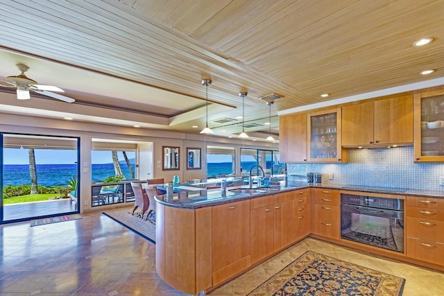 160 Pualei Dr Unit 160-4, Lahaina, HI 96761 - kitchen with black appliances, a sink, a peninsula, dark stone counters, and brown cabinets