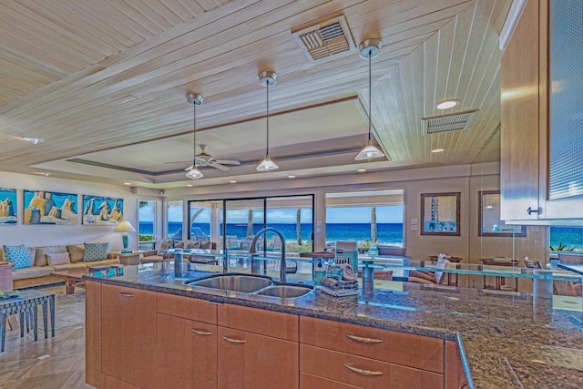 160 Pualei Dr Unit 160-4, Lahaina, HI 96761 - kitchen featuring a sink, a tray ceiling, dark stone counters, ceiling fan, and open floor plan