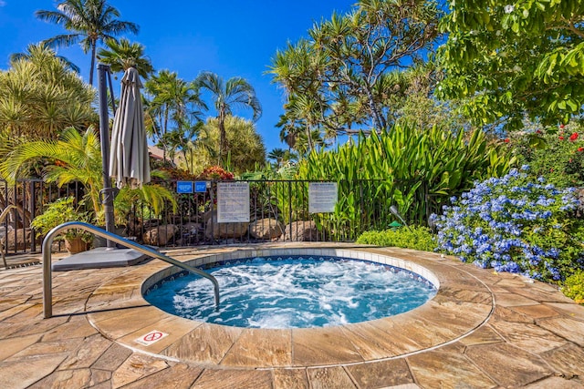 view of swimming pool with a hot tub