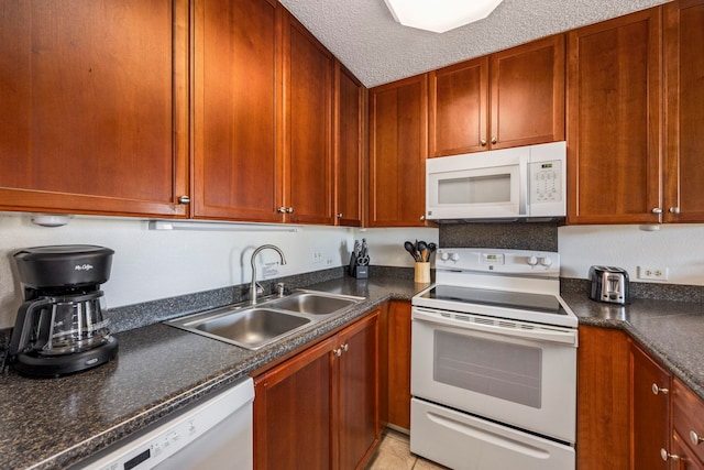 kitchen featuring a textured ceiling, sink, light tile patterned floors, and white appliances