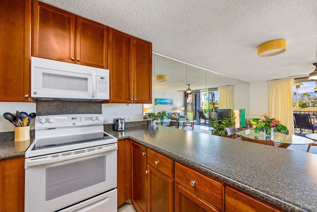 kitchen featuring decorative light fixtures, white appliances, and a textured ceiling