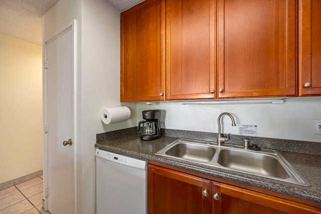 kitchen with light tile patterned floors, a textured ceiling, white dishwasher, and sink