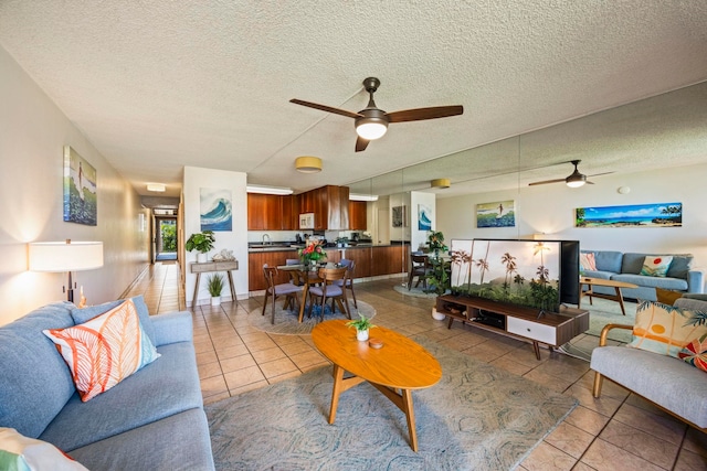 tiled living room featuring a textured ceiling, ceiling fan, and sink