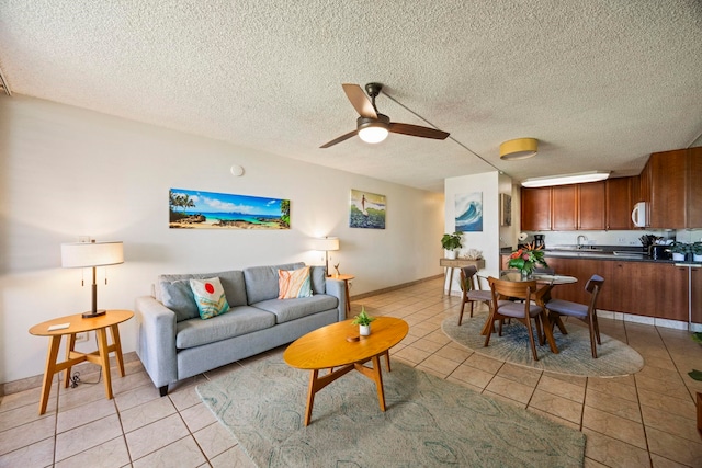 tiled living room with ceiling fan, sink, and a textured ceiling