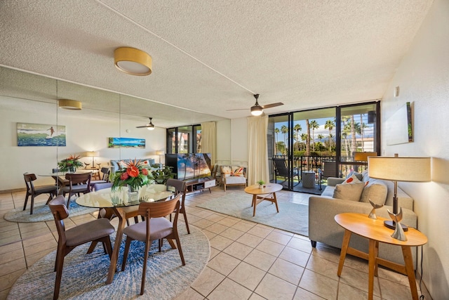 tiled dining room featuring ceiling fan, floor to ceiling windows, and a textured ceiling