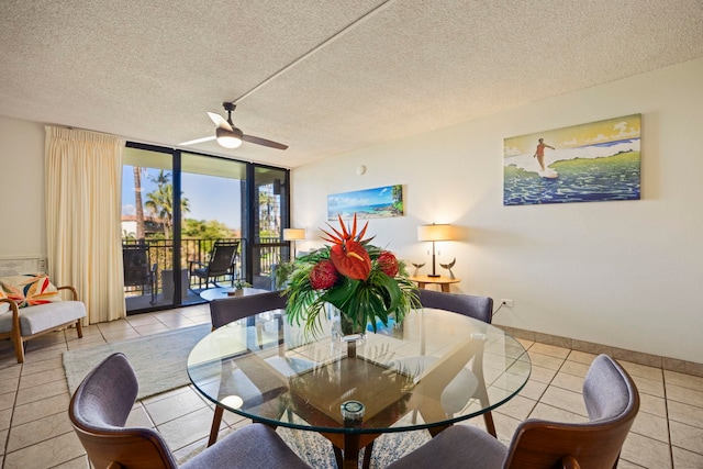 tiled dining space featuring a textured ceiling, a wall of windows, and ceiling fan