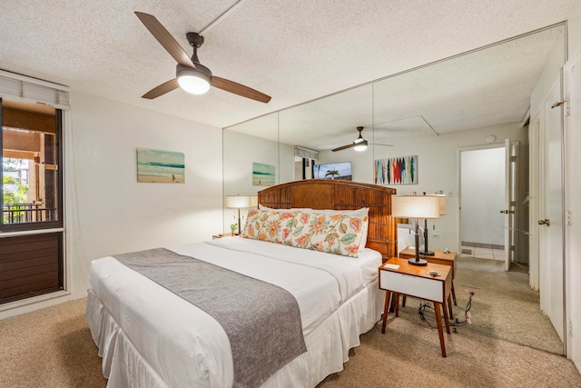 bedroom with ceiling fan, light colored carpet, and a textured ceiling