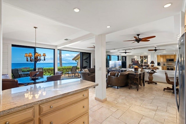 4850 Makena Alanui Rd Unit F-108, Kihei, HI 96753 - kitchen featuring pendant lighting, a water view, appliances with stainless steel finishes, open floor plan, and light stone countertops