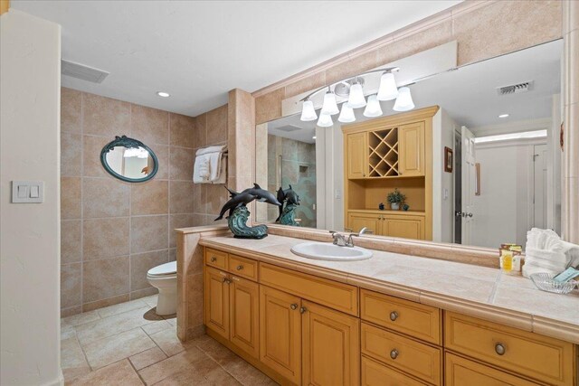 4850 Makena Alanui Rd Unit F-108, Kihei, HI 96753 - bathroom featuring toilet, visible vents, tile walls, and vanity