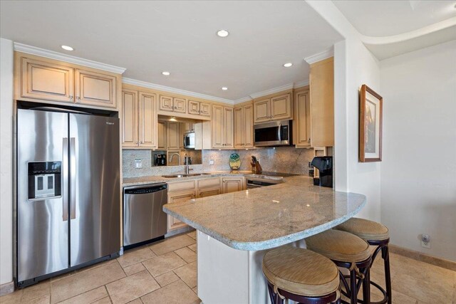 4850 Makena Alanui Rd Unit F-108, Kihei, HI 96753 - kitchen with light stone counters, a breakfast bar area, stainless steel appliances, a peninsula, and a sink