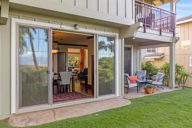 property entrance with a yard, a patio area, and a balcony