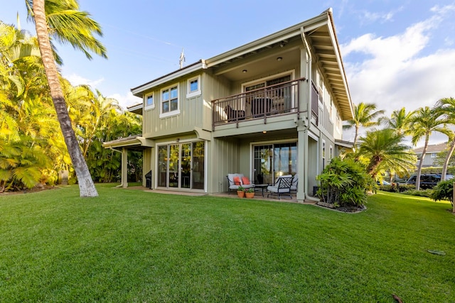 back of house with a lawn, a patio area, and a balcony